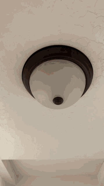 a person 's hand is reaching up to turn on a ceiling light