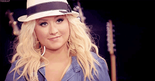 a blonde woman wearing a white hat with a black ribbon around the brim