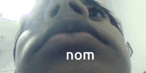 a close up of a person 's face with the word nom written on the bottom