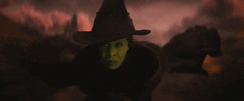 a witch with a green face and black hat