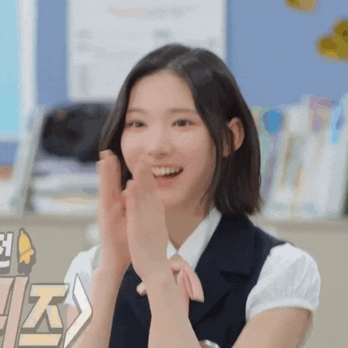 a woman in a school uniform is clapping her hands in a classroom