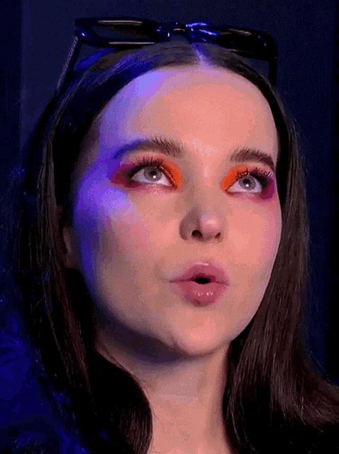 a close up of a woman 's face with colorful makeup