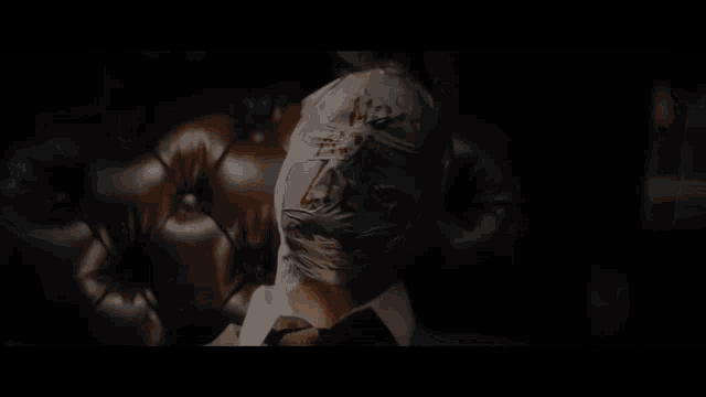 a man is wrapped in plastic with blood on his face