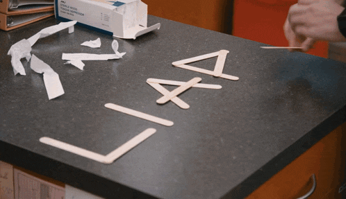 a box of tissues sits on a counter next to a box of popsicle sticks