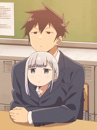 a man and a girl are sitting at a desk in front of a green board
