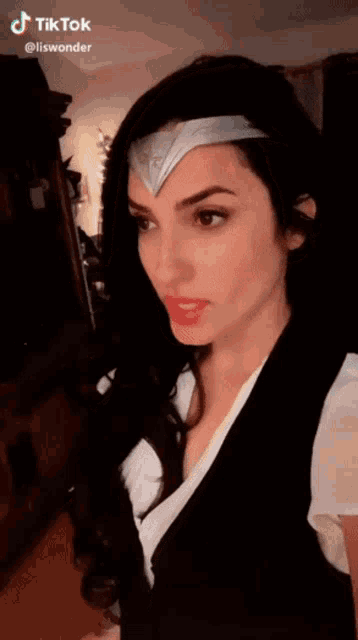 a woman in a wonder woman costume with a headband on her head .