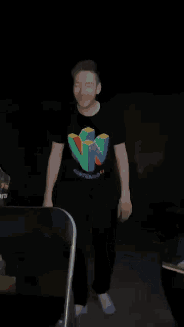 a man is dancing in a dark room next to a bottle of tower