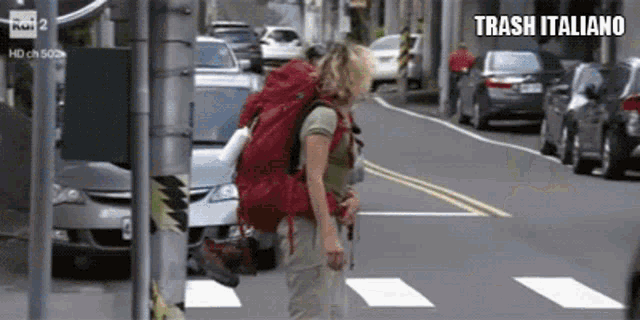 a woman with a red backpack is crossing a street and the words trash italiano are above her
