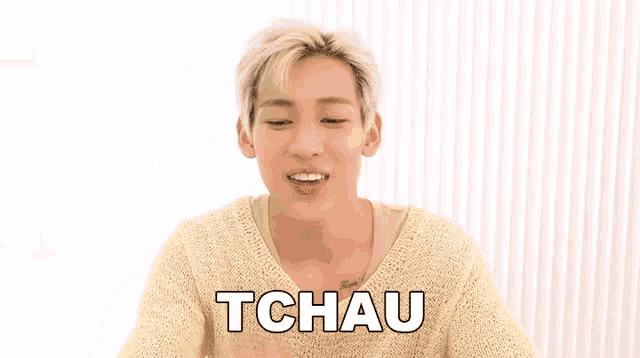 a man in a yellow sweater with the word tchau on the bottom