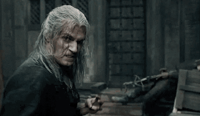 a man with gray hair is holding a sword in his hand .