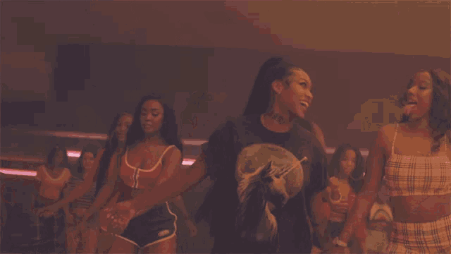a group of women are holding hands in a room