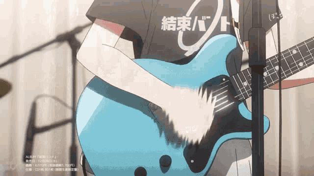 a person playing a guitar with a shirt that says 結束 バンド
