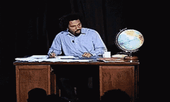 a man sitting at a desk with the words mais tu vas fermer ta gueule written on it