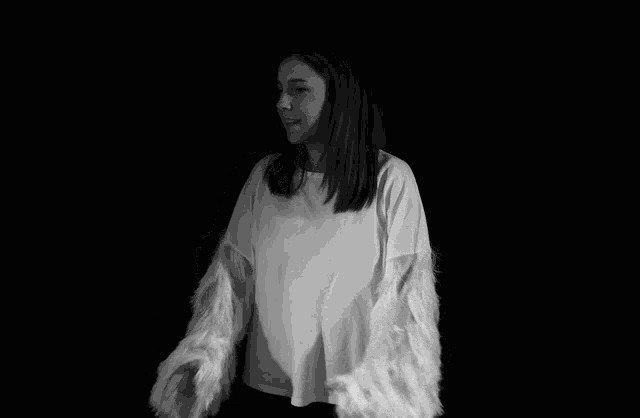 a black and white photo of a woman wearing a white sweater