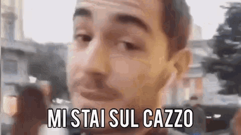 a close up of a man 's face with the words `` mi stai sul cazzo '' written above him .