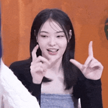 a woman is making a funny face and making a funny face with her hands .