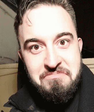 a man with a beard is making a face