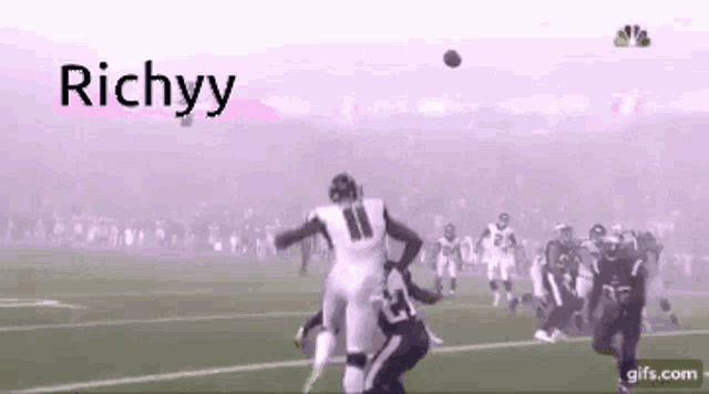 a football player throws a ball in the air with the word richyy behind him .