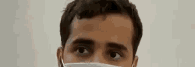 a man wearing a face mask with his eyes wide open .
