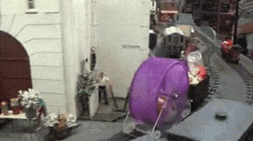 a purple bucket is sitting in front of a train track