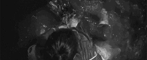 a man and a woman are standing in the water .