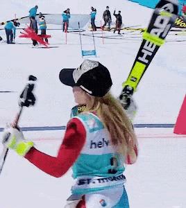 a woman holding a pair of skis with the word head on them