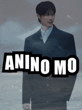 a man in a suit stands in front of a sign that says ' aninomo '