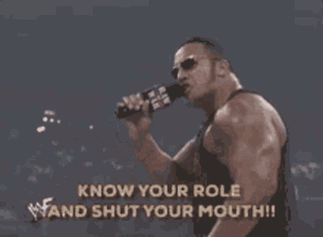 a man is holding a microphone and saying " know your role and shut your mouth !! "