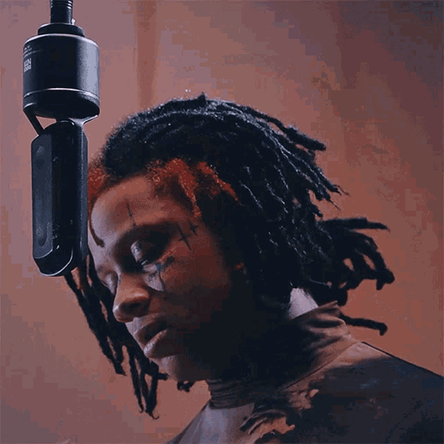 a woman with dreadlocks smoking a cigarette in front of a microphone that says jbl on it