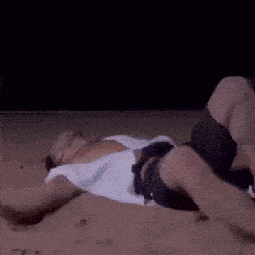 a man is laying on his back on a beach