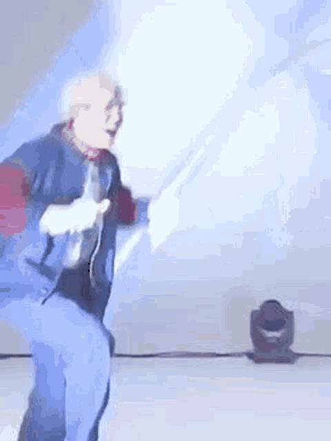 a man is dancing on a stage while holding a remote control .