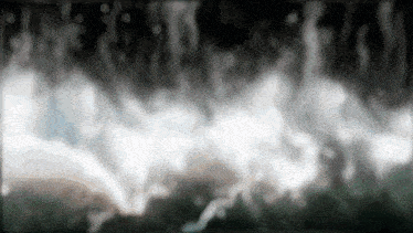 a blurred image of smoke coming out of a pipe on a black background