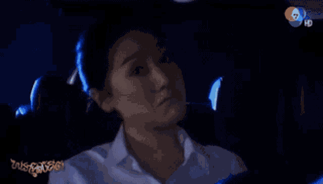 a woman is sitting in the back seat of a car with a tv screen behind her