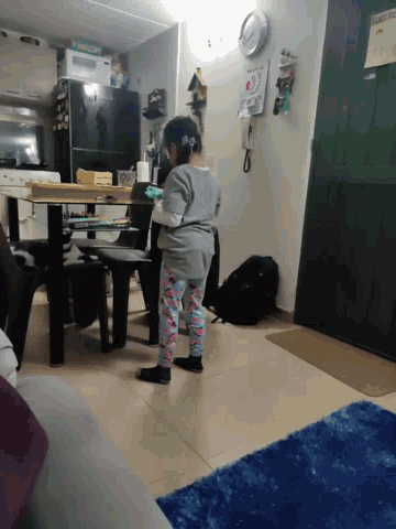 a person standing in a living room with a sign on the wall that says ' i love you ' on it