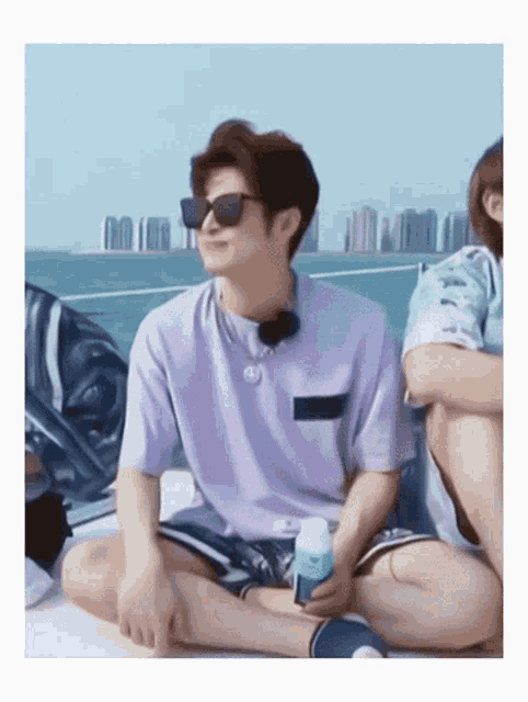 a man wearing sunglasses sits on a boat