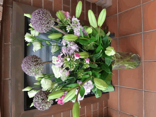 a vase filled with flowers sits on a tile floor
