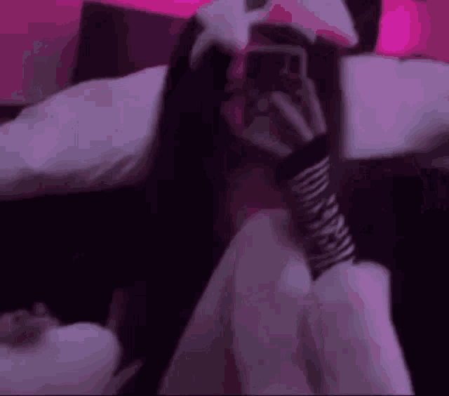 a girl is sitting on a bed taking a picture of herself with her phone .