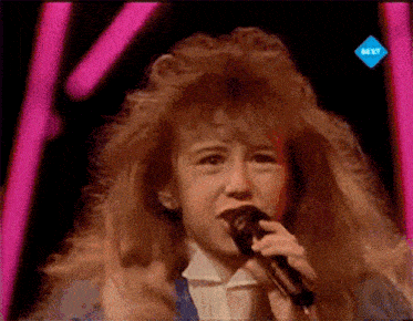 a young girl singing into a microphone on a tv screen that says nl tv