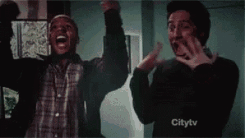 a couple of men are standing next to each other with their hands in the air .