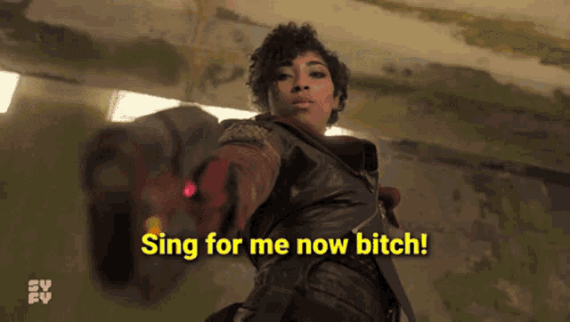 a woman is singing for me now bitch while holding a red object