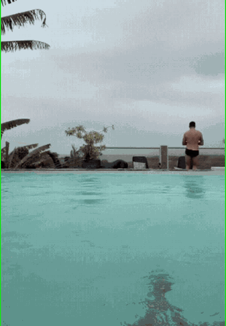 a man is standing in the middle of a swimming pool on a cloudy day