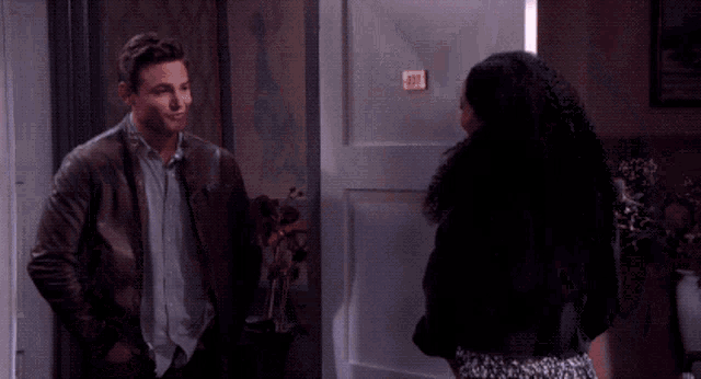 a man and a woman are standing in a doorway smiling