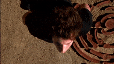 a man is laying on the ground in front of a maze