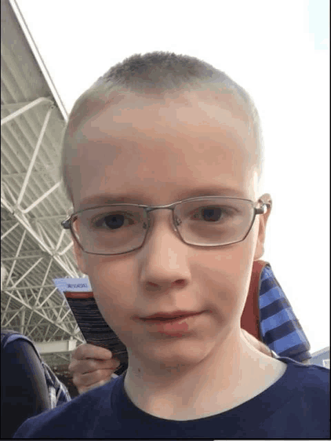 a young boy wearing glasses holds a ticket that says arrivals