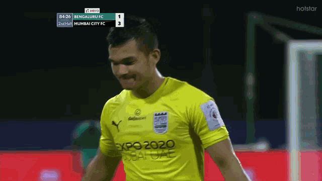 a soccer player wearing a yellow jersey that says expo 2020