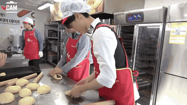 a man wearing a chef 's hat and apron is rolling dough