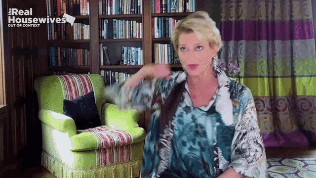 a woman is sitting in a chair in front of a bookshelf that says real housewives out of context