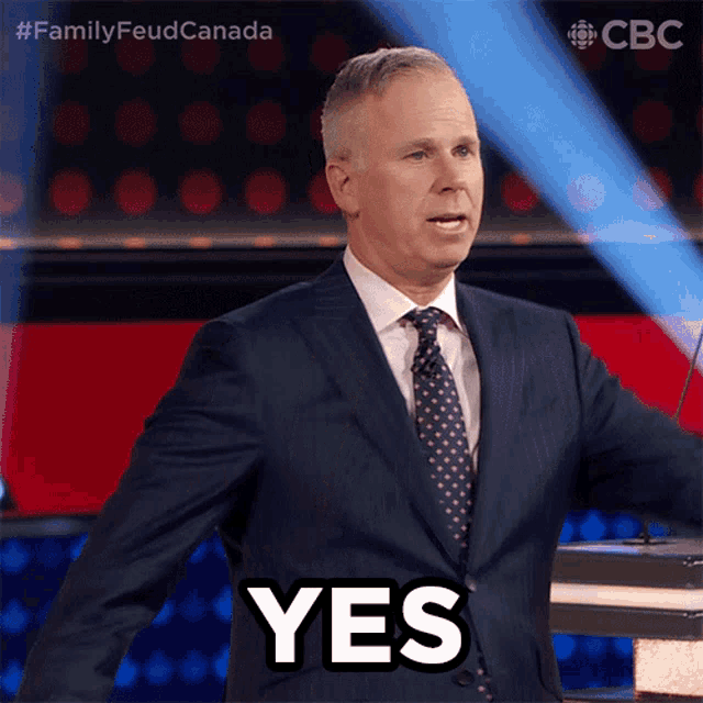 a man in a suit and tie is giving a speech and the word yes is above him