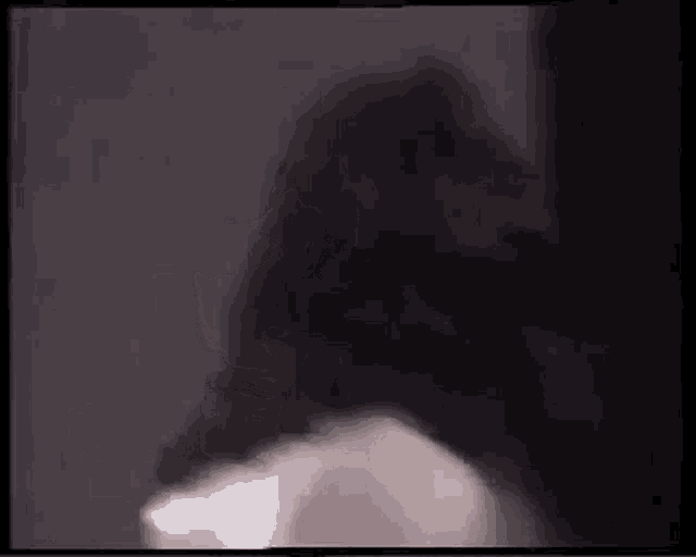 a close up of a person 's face in a dark room with a blurred background .