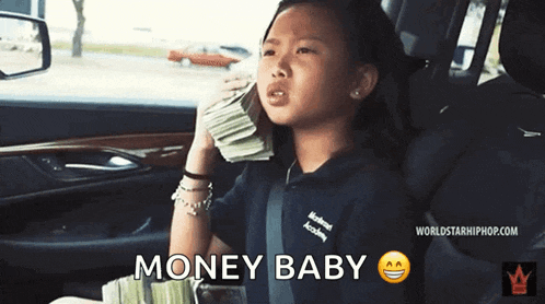 a young girl is sitting in a car holding a stack of money ..